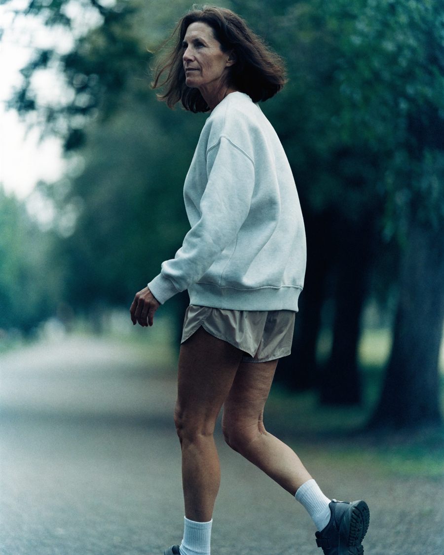 A woman walking outdoors on a bright autumn afternoon